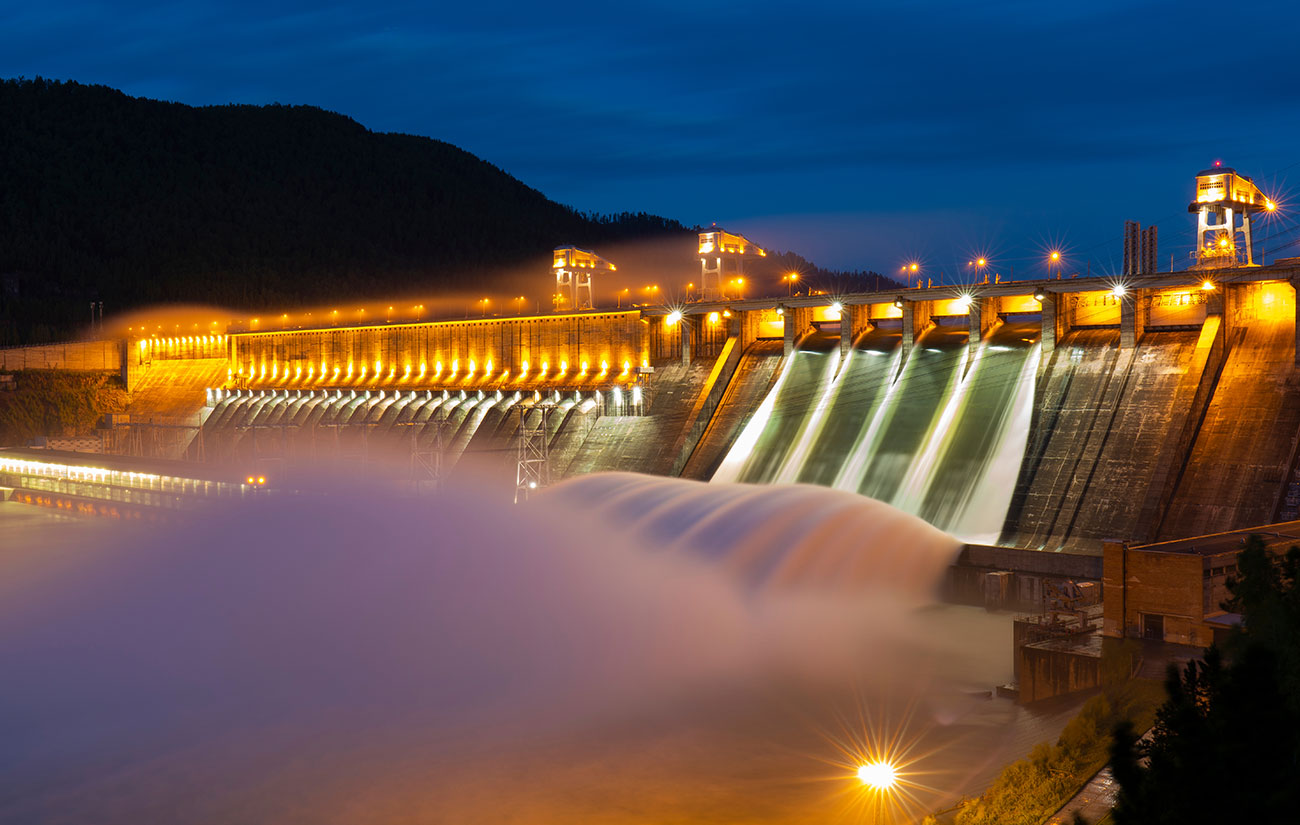 A waterfall at a dam at night time