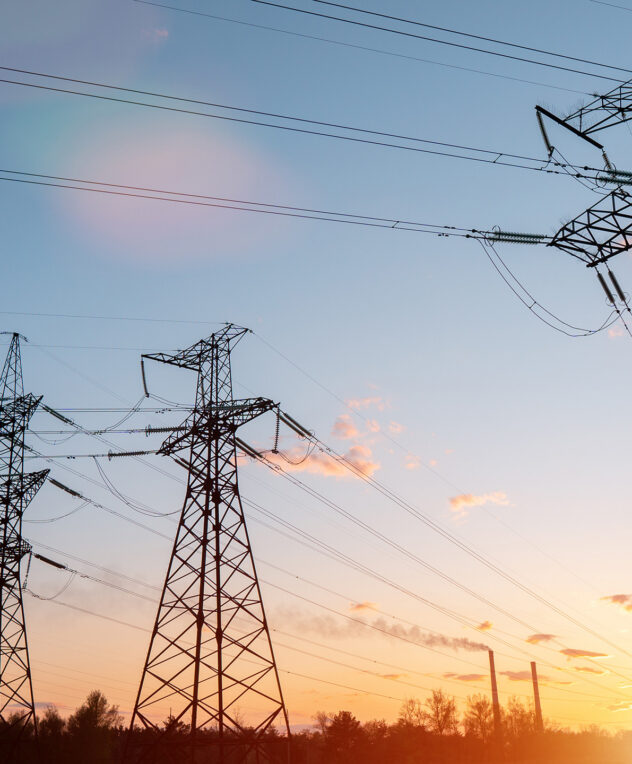 High Voltage Transmission Towers And Power Lines At Sunset, Side View