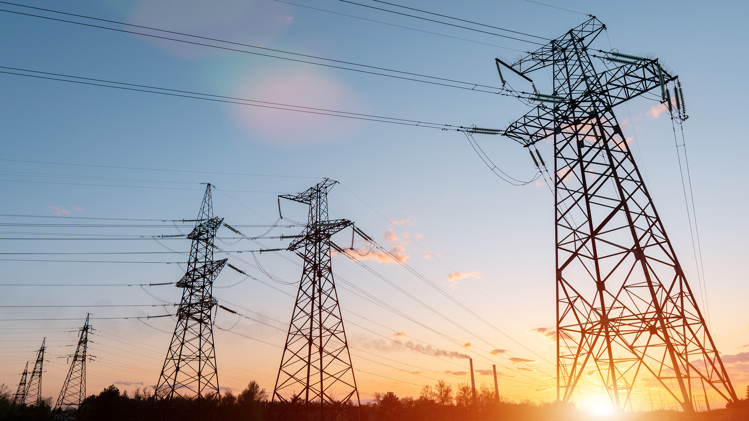 High Voltage Transmission Towers And Power Lines At Sunset, Side View